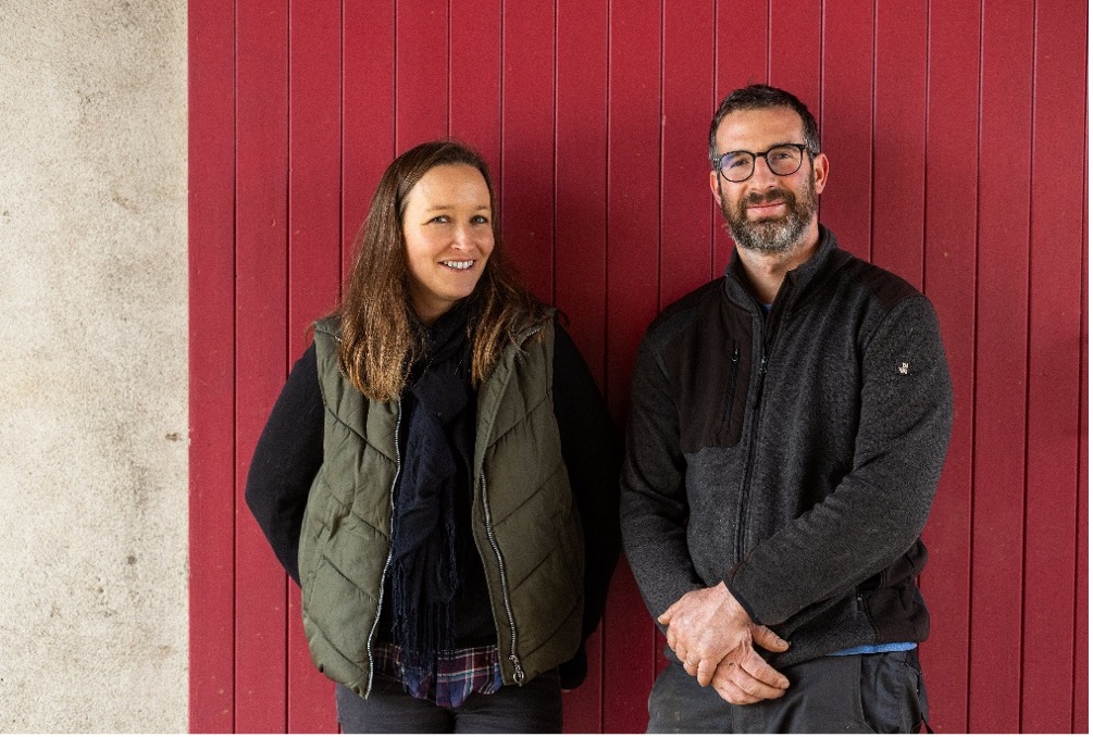 Amélie Berthaut and Nicolas Faure standing among vineyard rows in Bourgogne, illustrating hands-on estate management and grower presence.